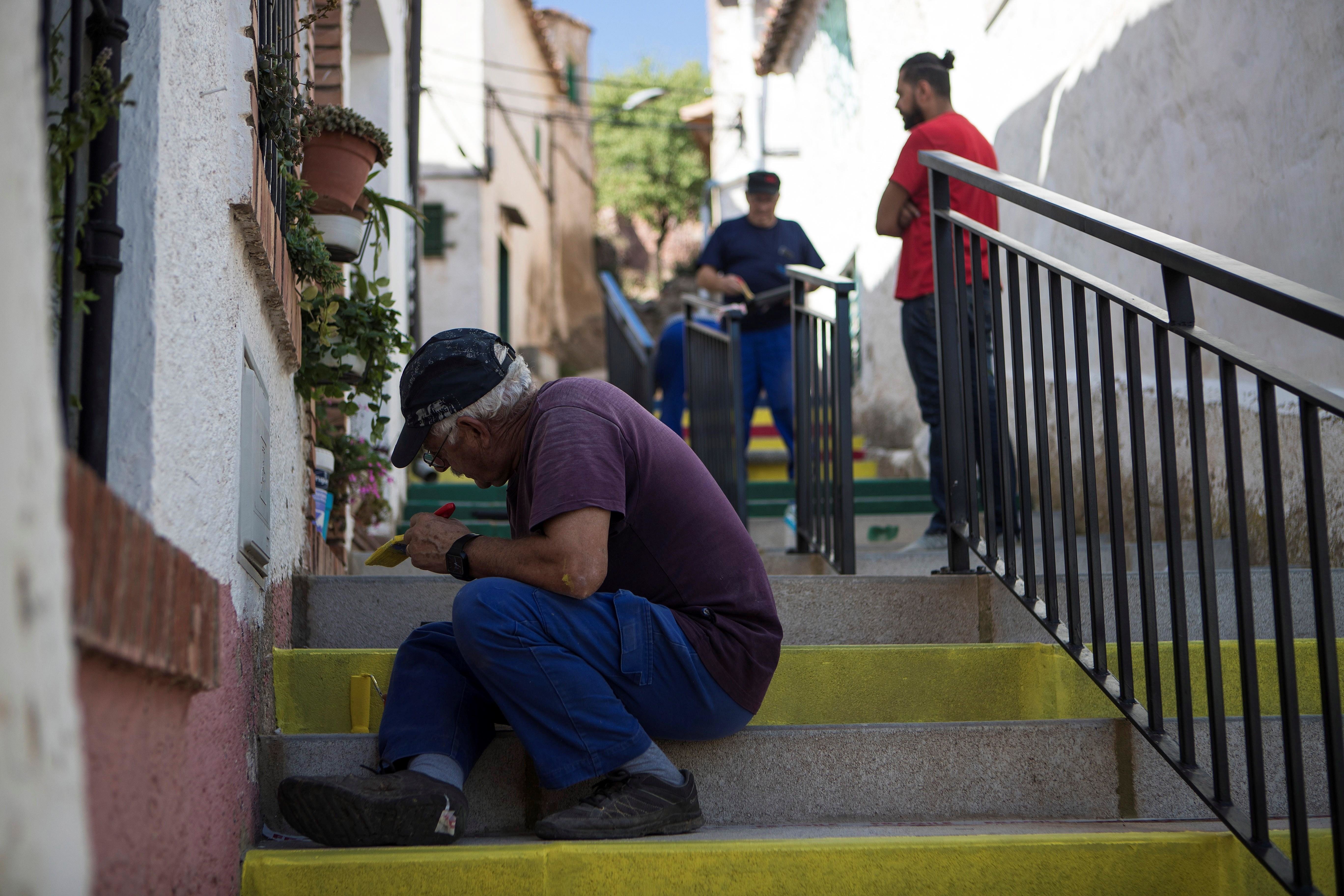 Los vecinos ayudan a KhaÃ¯ri Jemli a pintar una escalera de AladrÃ©n con "los colores de la alegrÃ­a".