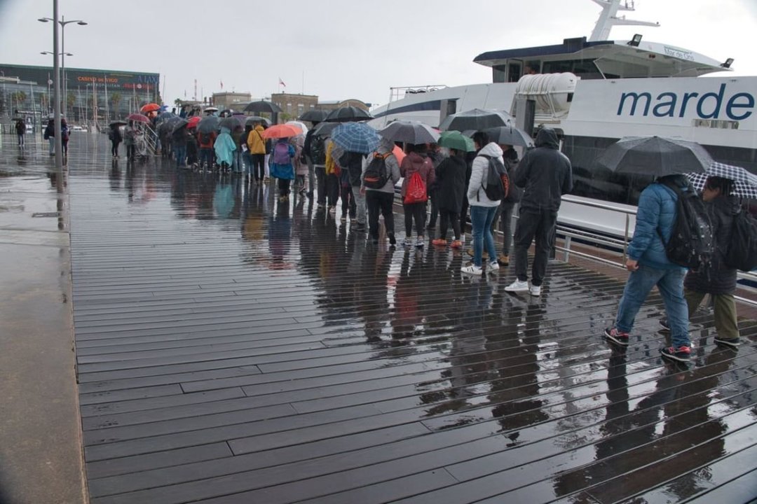 Una fila de paraguas, a la espera de embarcar ayer con destino Cíes en el muelle vigués.