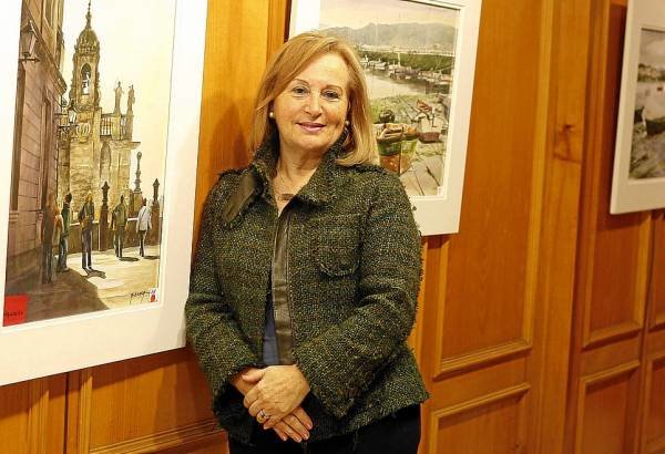 Mª Carmen Álvarez Braga posa con uno de sus cuadros, que se exponen en el Mercantil. foto: j.v.landin.