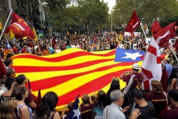 Miles de personas observan como se despliega una bandera independentista catalana. (Foto: M.PÉREZ)