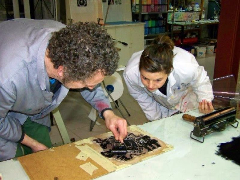 Marc Taeger aplicando la técnica del linóleo con los profesores Alba Pardo