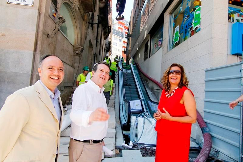 David Regades, Abel Caballero y Carmela Silva observar la grúa que ayer colocó el primer tramo de las escaleras mecánicas. 