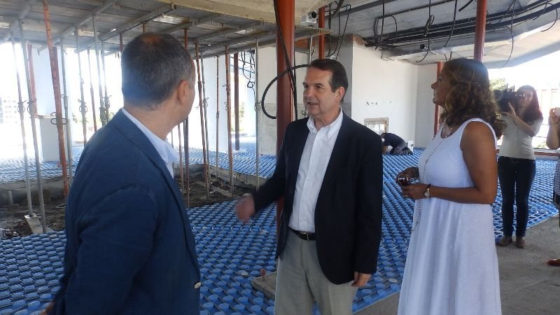 Caballero conversa con Regades ante Silva durante su visita a la escuela infantil de Navia.