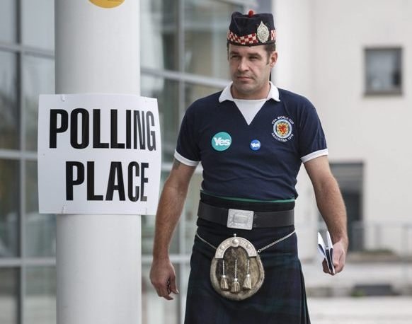 Un hombre con la falda típica escocesa acude a votar.