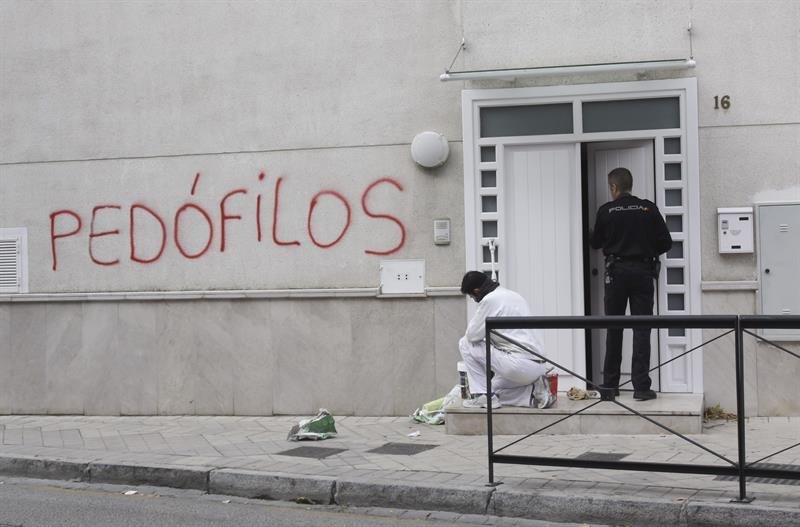 Un pintor momentos antes de repasar con pintura blanca una de las pintadas aparecidas en rojo esta mañana con acusaciones de pedofilia y pederastia en una pared de la parroquia San Juan María Vianney de Granada
