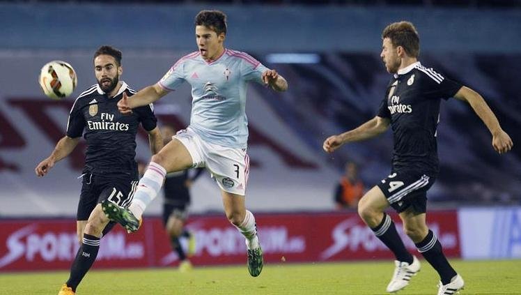 El delantero del Celta de Vigo Santi Mina (i) lanza a puerta entre Daniel Carvajal (i) y Asier Illarramendi, del Real Madrid