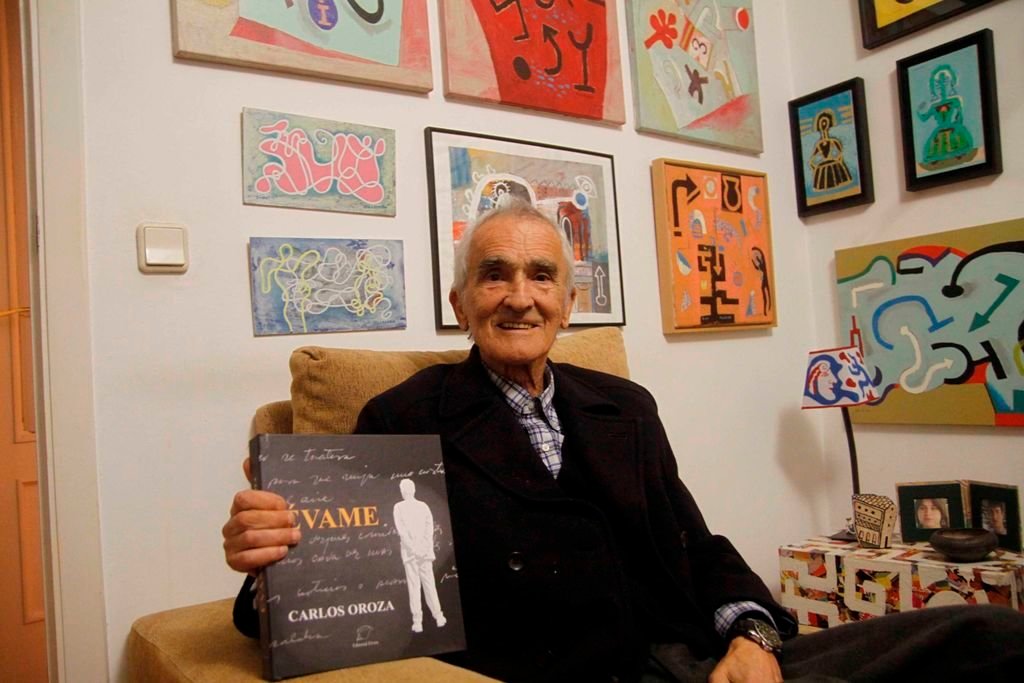 Carlos Oroza, en su domicilio, con su libro “Évame”, volumen que reúne su obra revisada y cuya edición era de la él más se sentía satisfecho como culminación de su trayectoria.