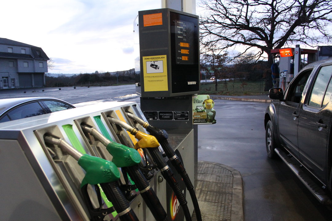 Dos turismos repostan combustible en una estación de servicio.