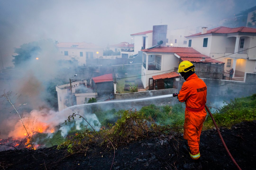 Un bombero trabaja en la extinción de un incendio en la parte alta de Funchal, capital de Madeira.