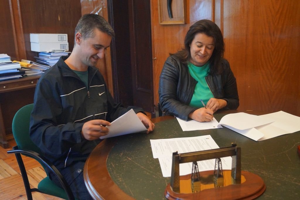 El director de la escuela y al alcaldesa accidental durante la firma del convenio.
