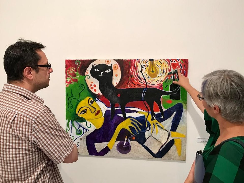 Dos personas observan una de las obras de la pintora viguesa Teresa Irisarri expuesta en la Casa de Galicia en Madrid.