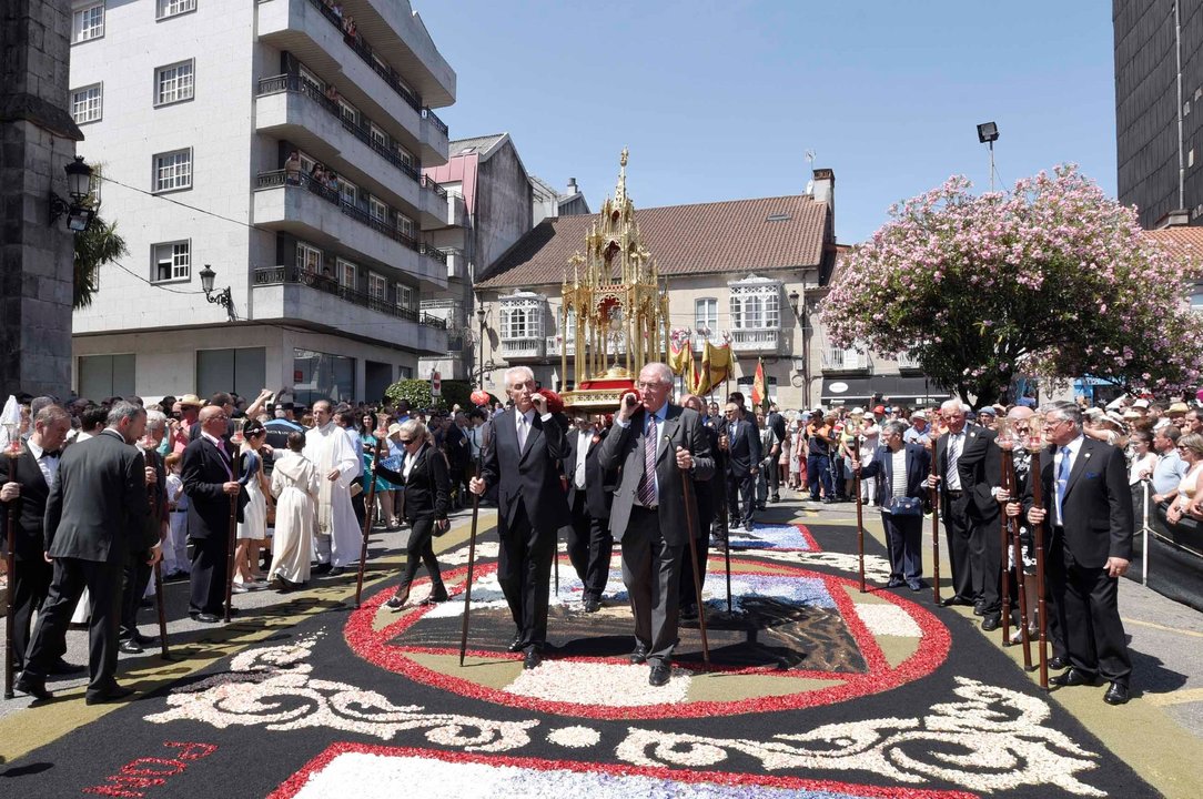 La salida de la procesión con la Custodia del Santísimo y sobre la primera alfombra del recorrido.