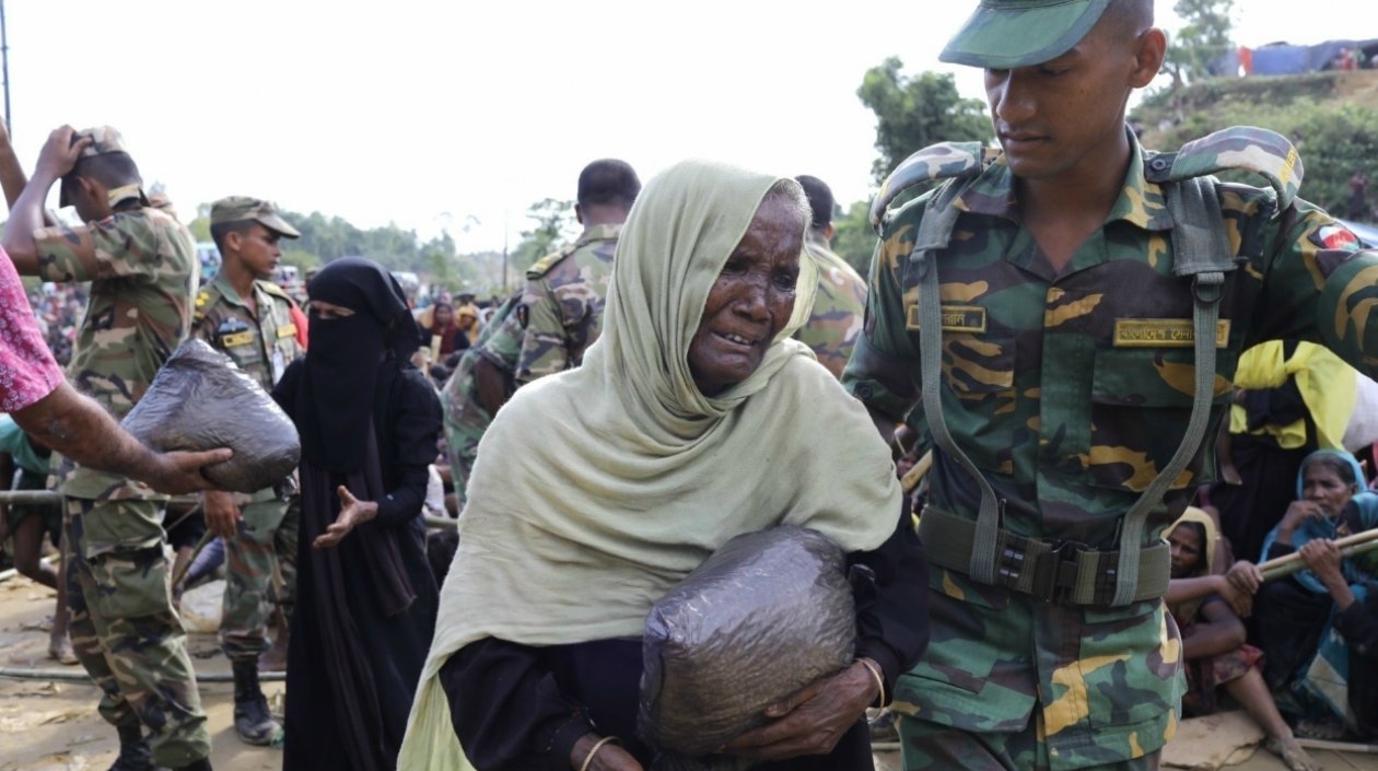 Una refugiada de la etnia rohingya es auxiliada por un militar de Bangladesh en su huída de Birmania.