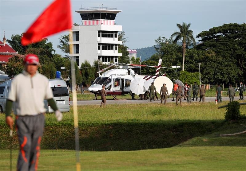 Un golfista tailandés juega en un campo próximo al lugar donde soldados y policías tailandeses evacúan en helicóptero a uno de los niños