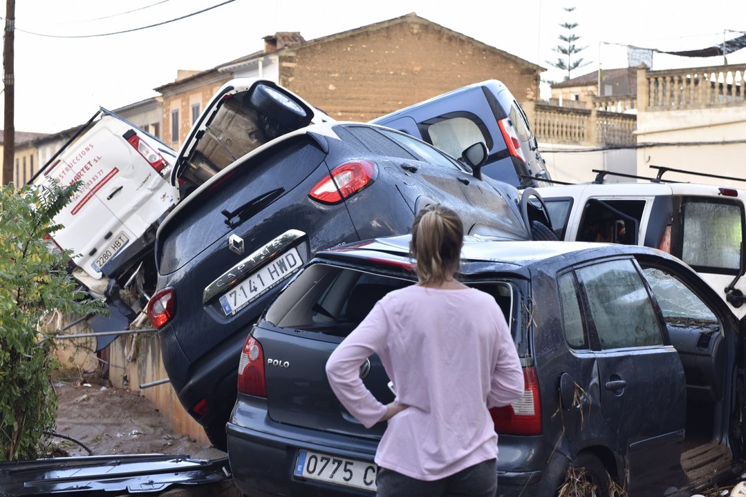 Una mujer observa los coches amontonados por la riada en una calle de la localidad de Sant Llorenç des Cardassar.