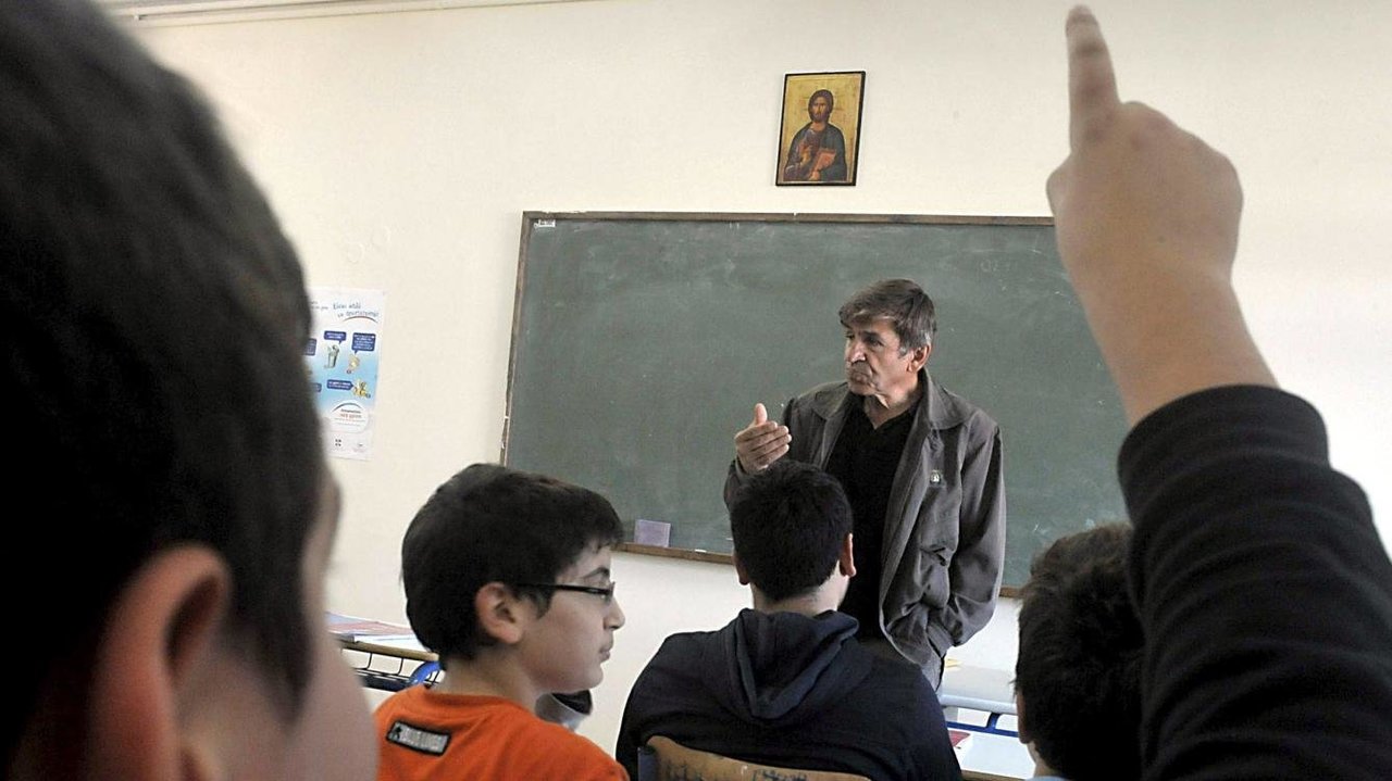 Un grupo de alumnos escucha a su profesor de religión durante una clase.