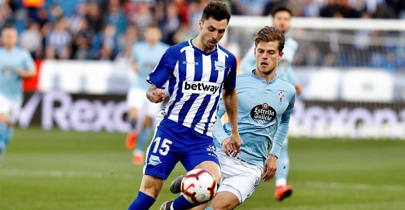 El defensa del Deportivo Alavés, Ximo Navarro (i), protege el balón ante el centrocampista danés del Celta