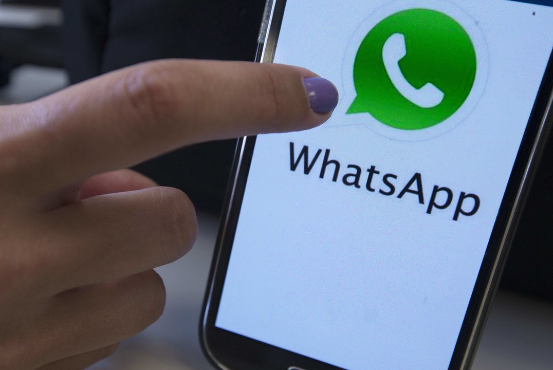 Fotografía de un teléfono móvil con el logo de la popular aplicación de mensajería WhatsApp.