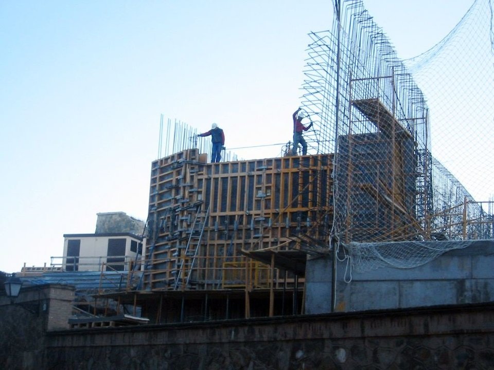 Dos obreros trabajan en la construcción de un bloque de viviendas.