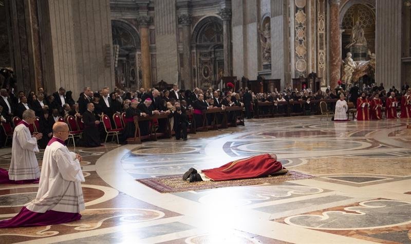 El papa Francisco (c) se tumba para rezar durante la ceremonia de la Pasión del Señor