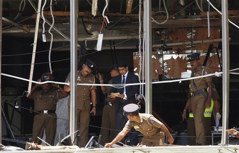 La policía de Sri Lanka investiga la escena tras la explosión.