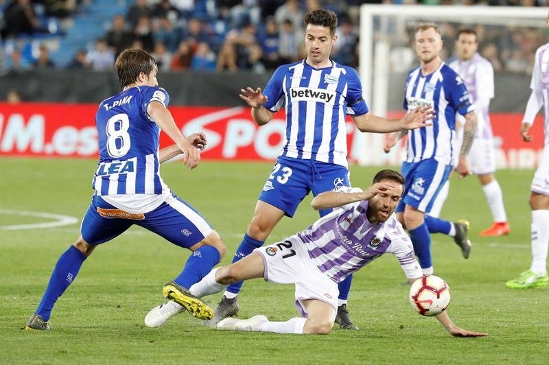 El centrocampista del Real Valladolid Míchel (d) cae ante Jony (c) y Pina, ambos del Deportivo Alavés