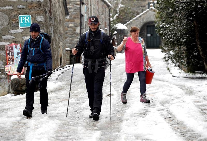 Unos peregrinos caminan por una calle nevada de O Cebreiro, Lugo