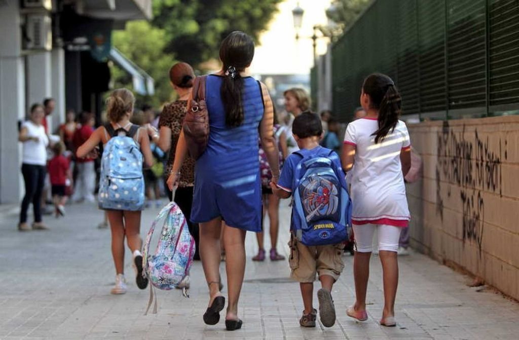 Varios niños y niñas acuden con su padres y a amigos al colegio.