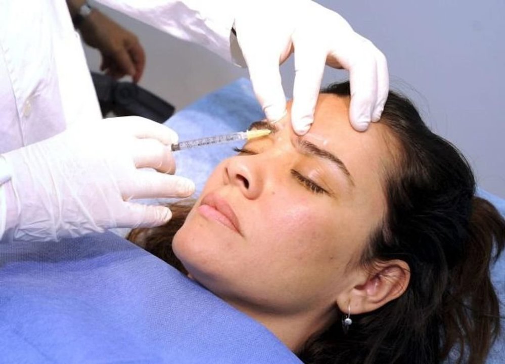 Una mujer recibe tratamiento de belleza facial en una clínica especializada.