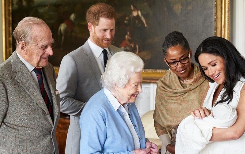 El príncipe Enrique de Inglaterra (2i) y la duquesa de Sussex, Meghan Markle (d), presentan a su hijo recién nacido, Archie Harrison Mountbatten-Windsor, a la madre de la duquesa de Sussex, Doria Ragland (2d), y a la reina Isabel II de Inglaterra (c) y a su esposo Felipe, duque de Edimburgo