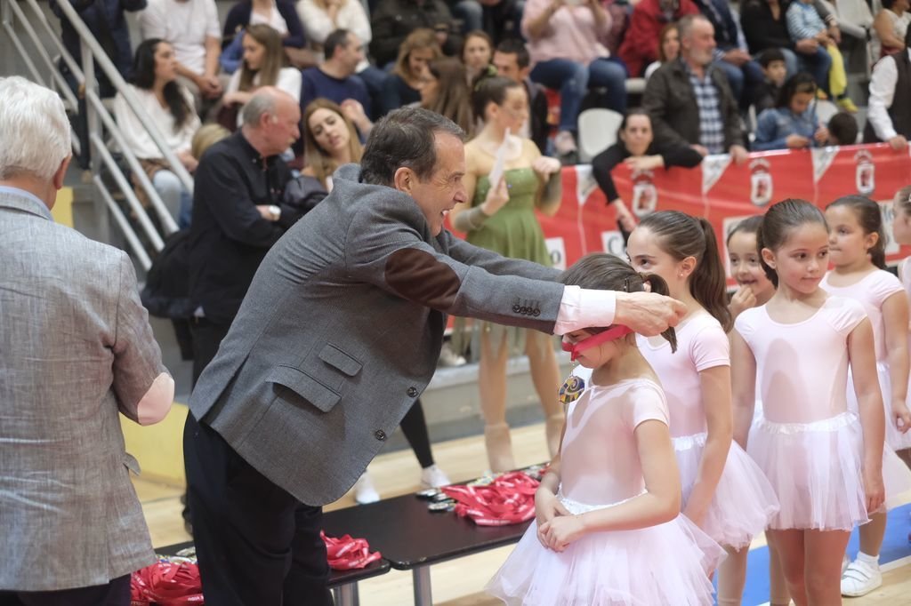 El alcalde de Vigo, Abel Caballero, pone medallas conmemorativas a un grupo de jóvenes patinadoras.