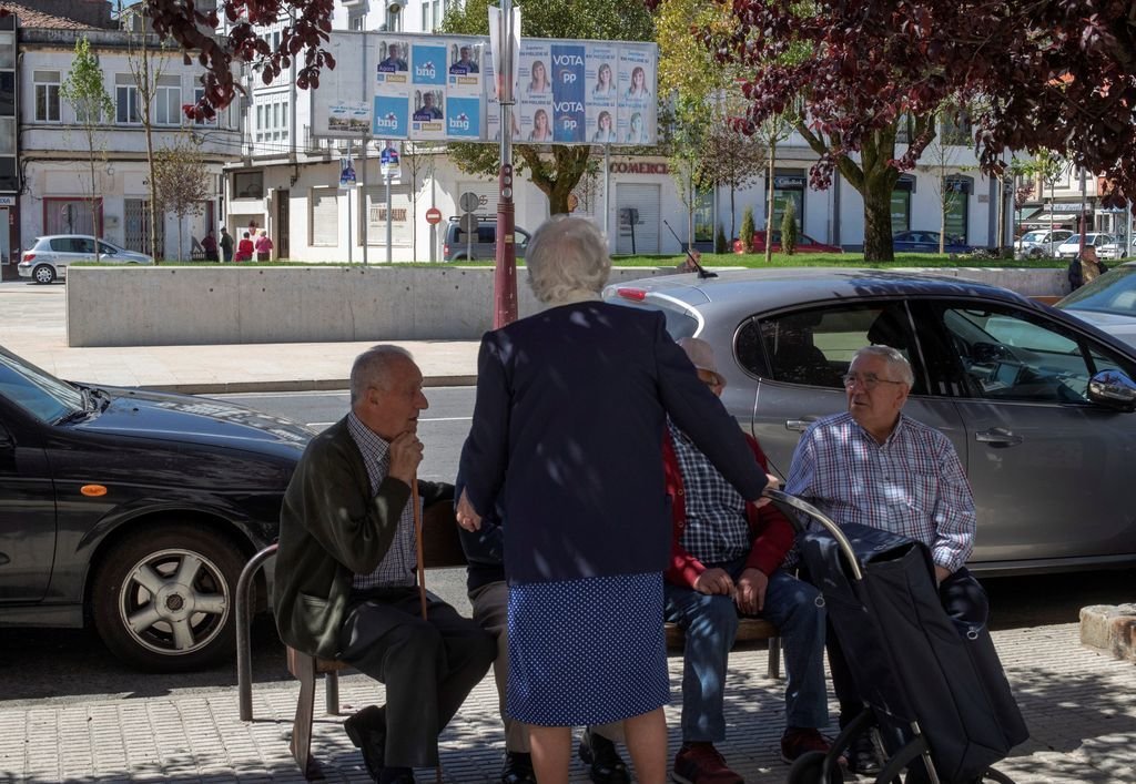Un grupo de personas mayores conversa en Melide (A Coruña).