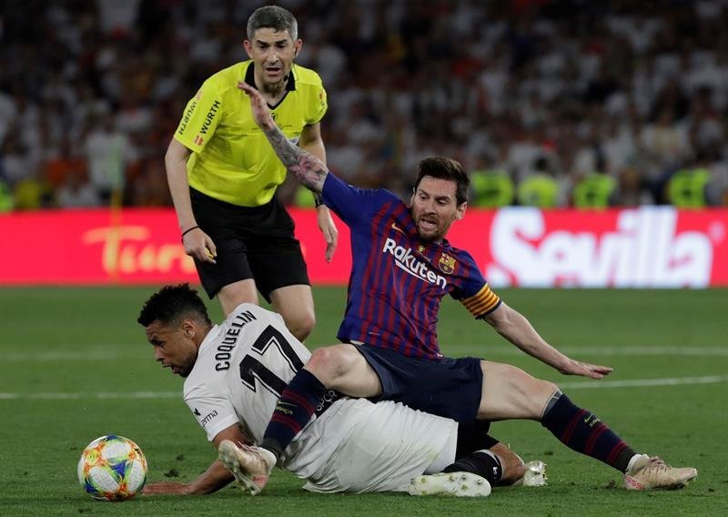 El jugador argentino del FC Barcelona Leo Messi cae ante el francés Francis Coquelin, del Valencia CF, durante la final de la Copa del Rey