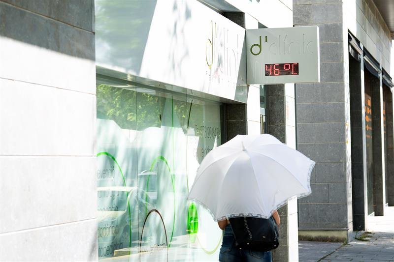 Una mujer pasea protegida por un paraguas en Lleida