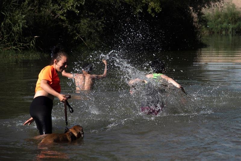 Unos jóvenes se bañan en el Rio Segre a su paso por Lleida, ciudad afectada por la ola de