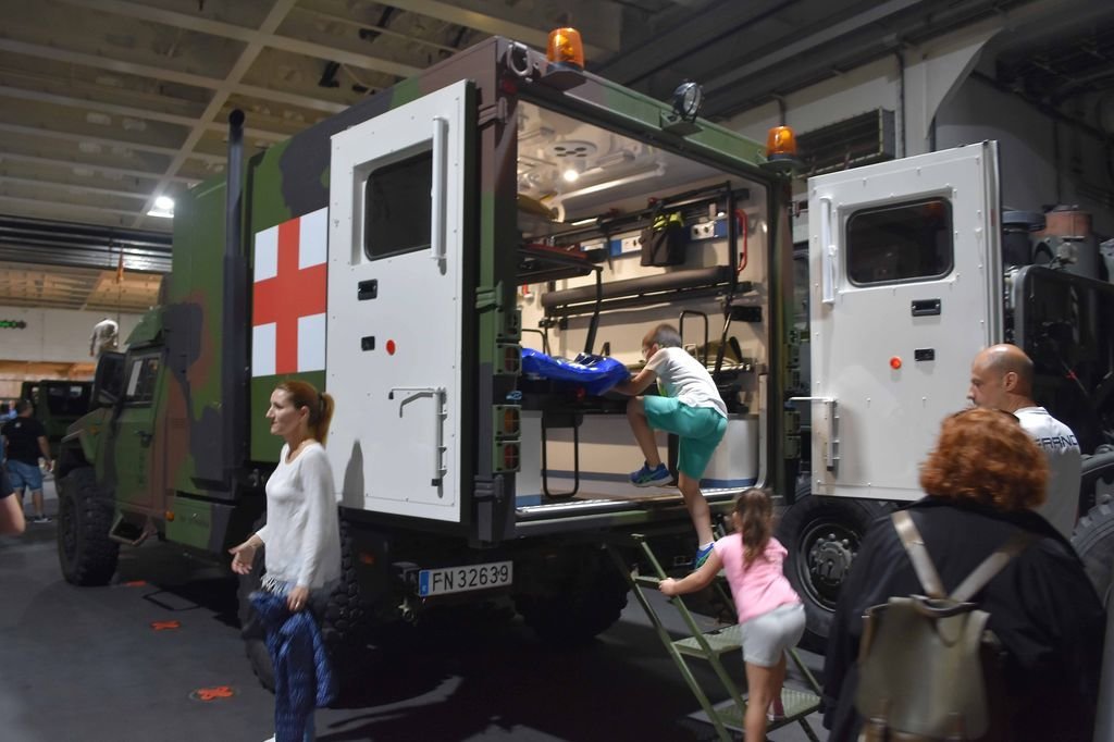 Niños suben a la ambulancia durante la visita al hangar