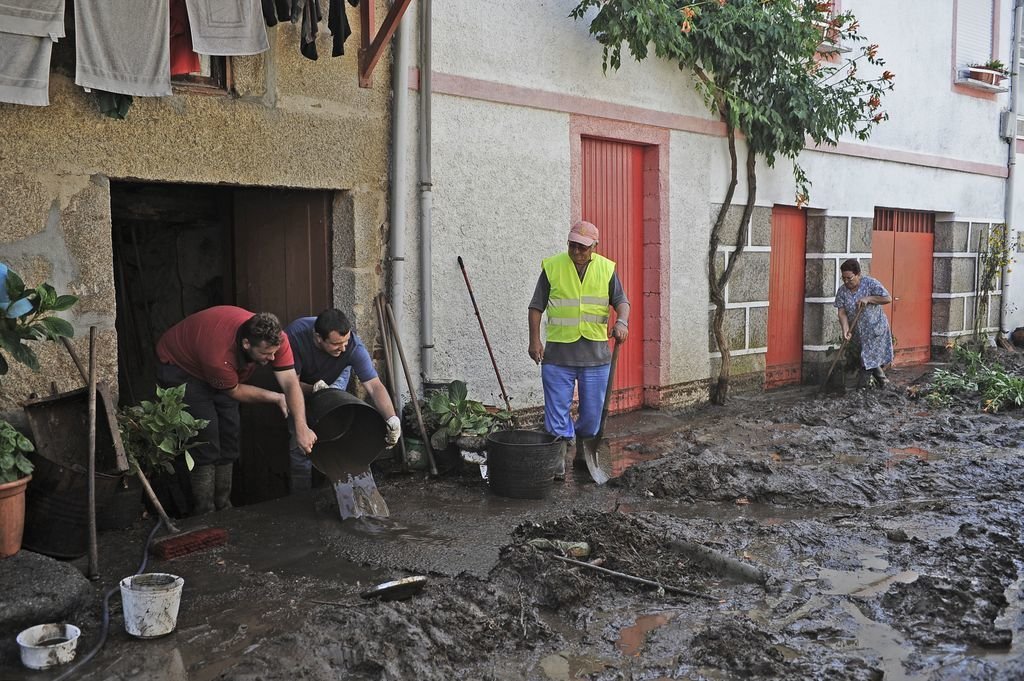 Vecinos de la parroquia de Infesta, en el concello ourensano de Monterrei, limpian tras la riada.