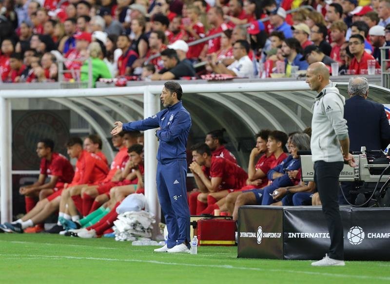 El entrenador del Bayern Munich, Niko Kovac (c), da instrucciones junto al técnico del Real Madrid, Zinedine Zidane (d)