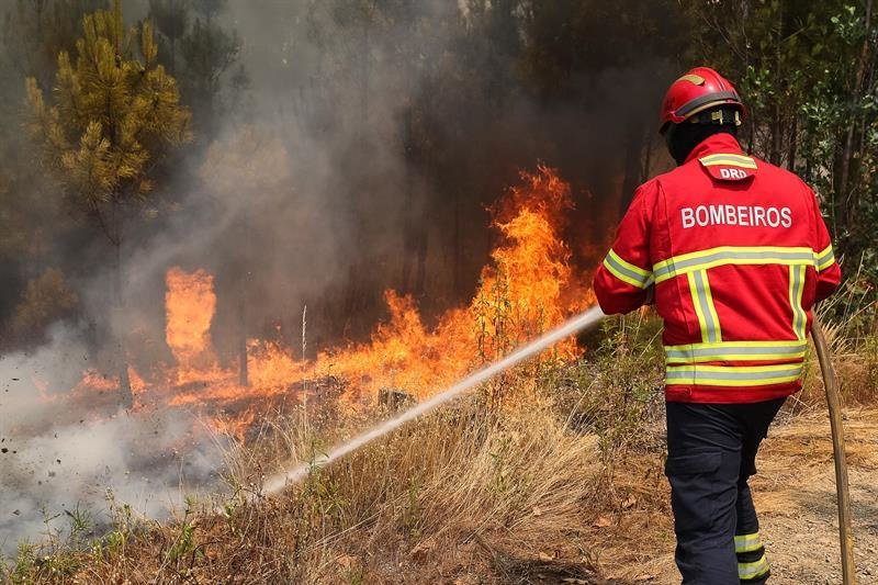 Un bombero intenta extinguir un incendio forestal en Sarnada, cerca de Macao, Portugal,