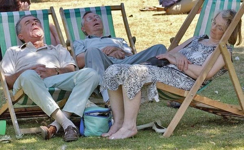 Personas mayores toman una siesta al mediodía al aire libre.