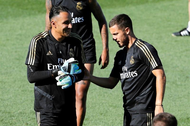 El jugador belga del Real Madrid Eden Hazard (d) y el portero Keylor Navas, durante el entrenamiento del equipo