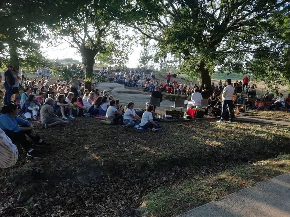 Público sobre una de las rocas con petroglifos en el Parque Arqueológico durante la actuación del gaitero vigués Carlos Núñez.
