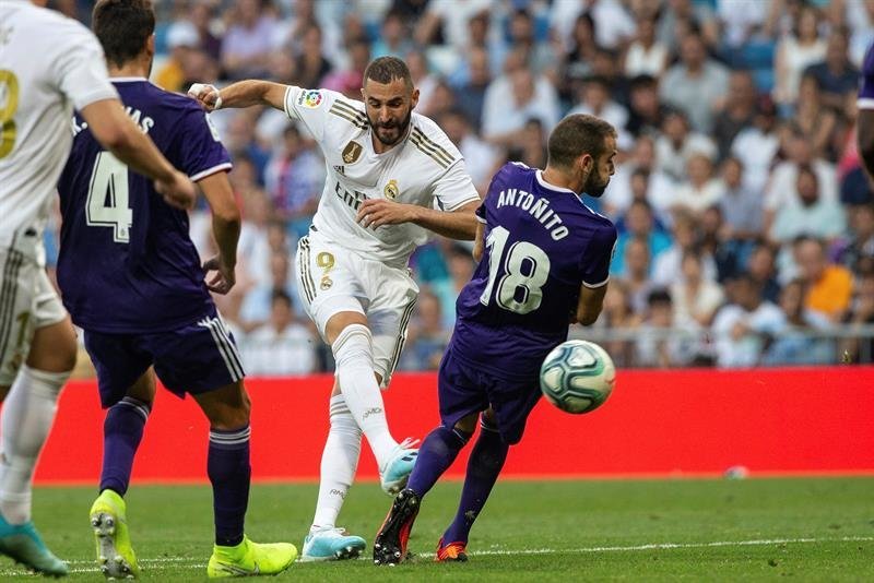 El delantero francés del Real Madrid, Karim Benzema (2d), golpea el balón ante el defensa del Real Valladolid, Antoñito