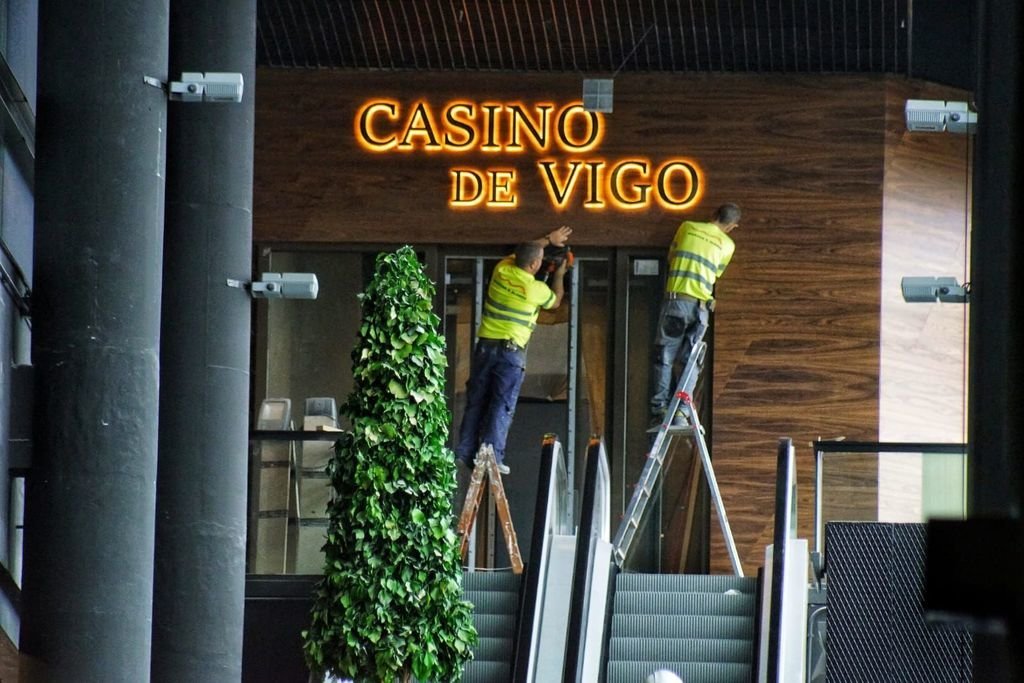 Colocando los carteles del Casino de Vigo en el centro comercial A Laxe.