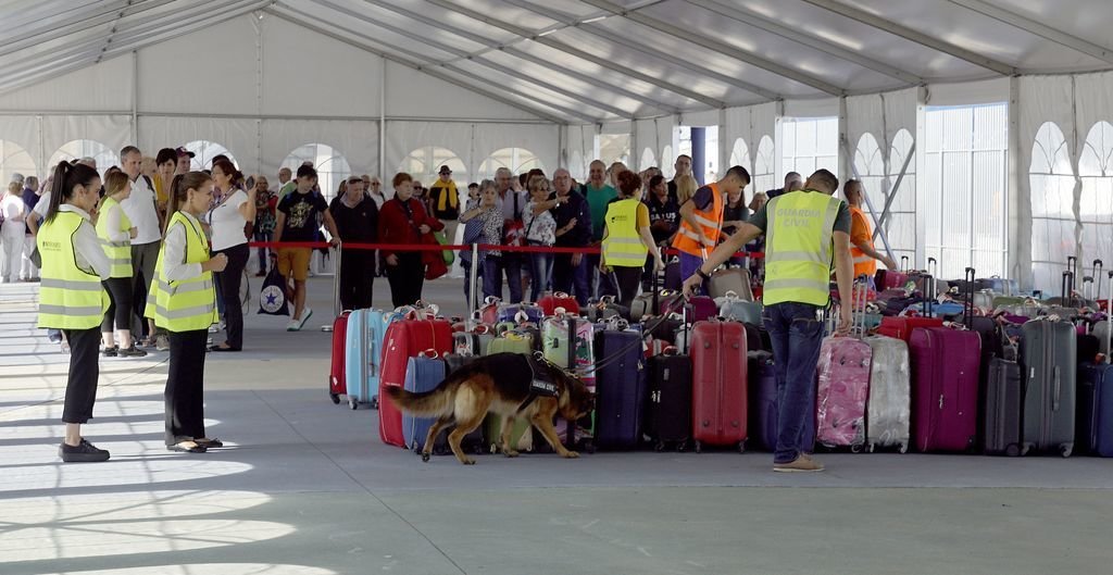La Guardia Civil inspecciona con perros especializados los equipajes de los viajeros.