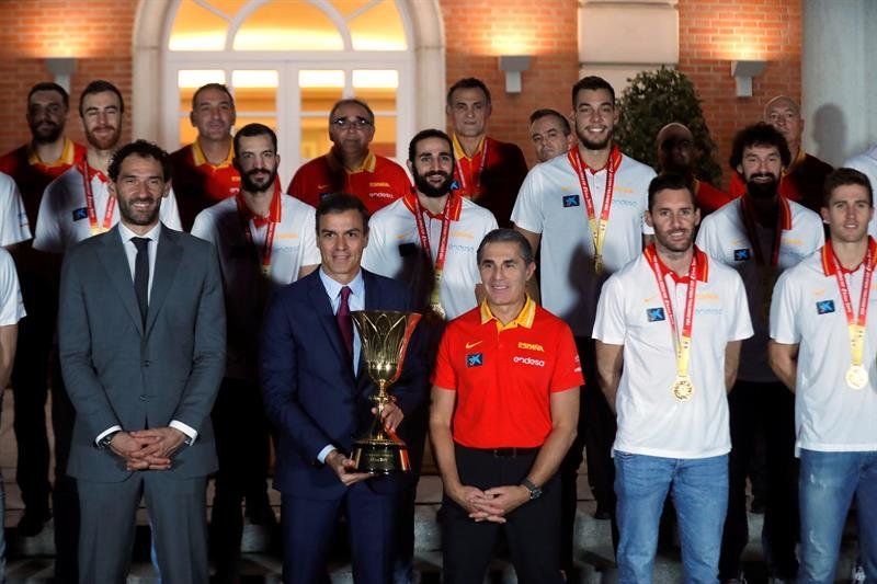 El presidente del Gobierno en funciones Pedro Sánchez (2i) sostiene la copa entre el seleccionador nacional de baloncesto Sergio Scariolo (c) y el presidente de la Federación Jorge Garbajosa (i)