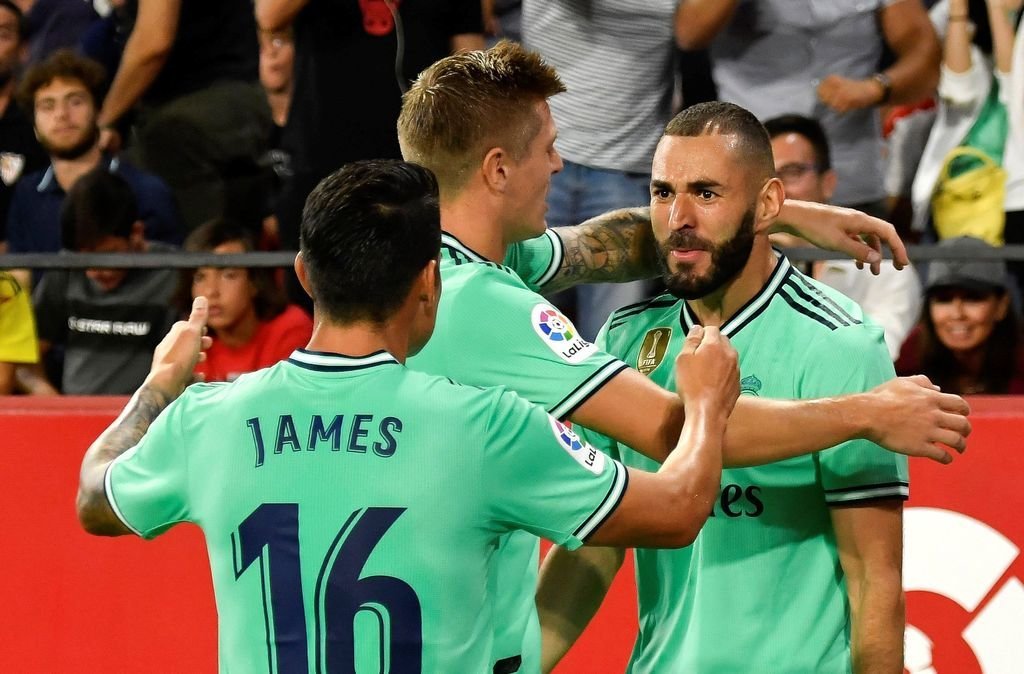 Benzema recibe la felicitación de Kroos y James Rodríguez tras el gol que marcó ayer en el Sánchez Pizjuán.