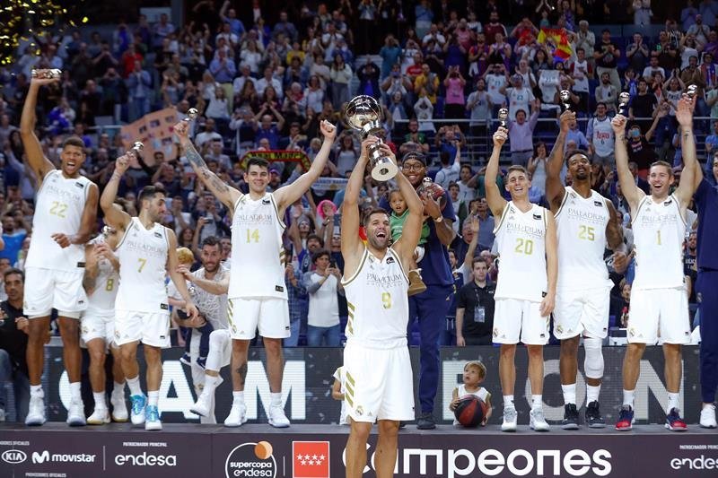 El capitán del Real Madrid Felipe Reyes (c), junto a sus compañeros, levanta la copa de campeón tras la final de la Supercopa Endesa que Real Madrid y Barça