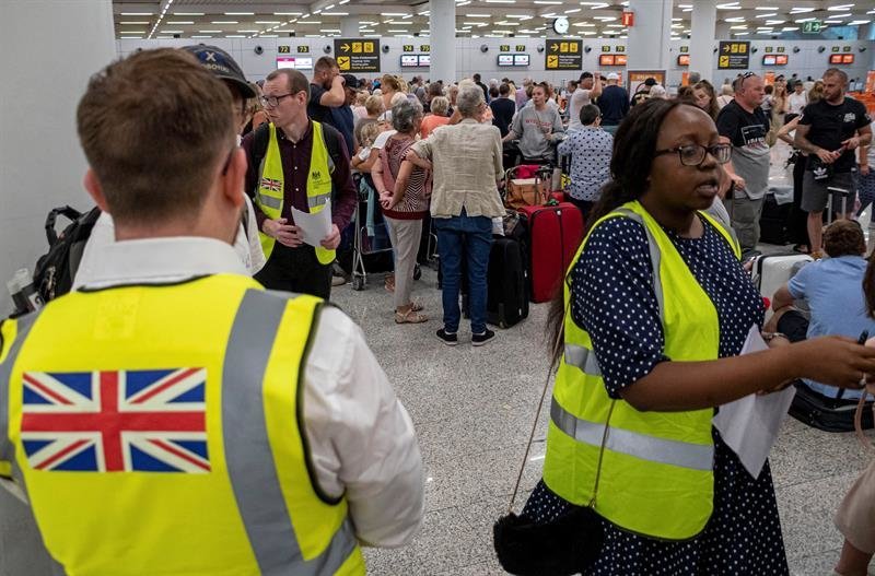 Empleados del gobierno británico atieden a los pasajeros en el aeropuerto de Palma de Mallorca