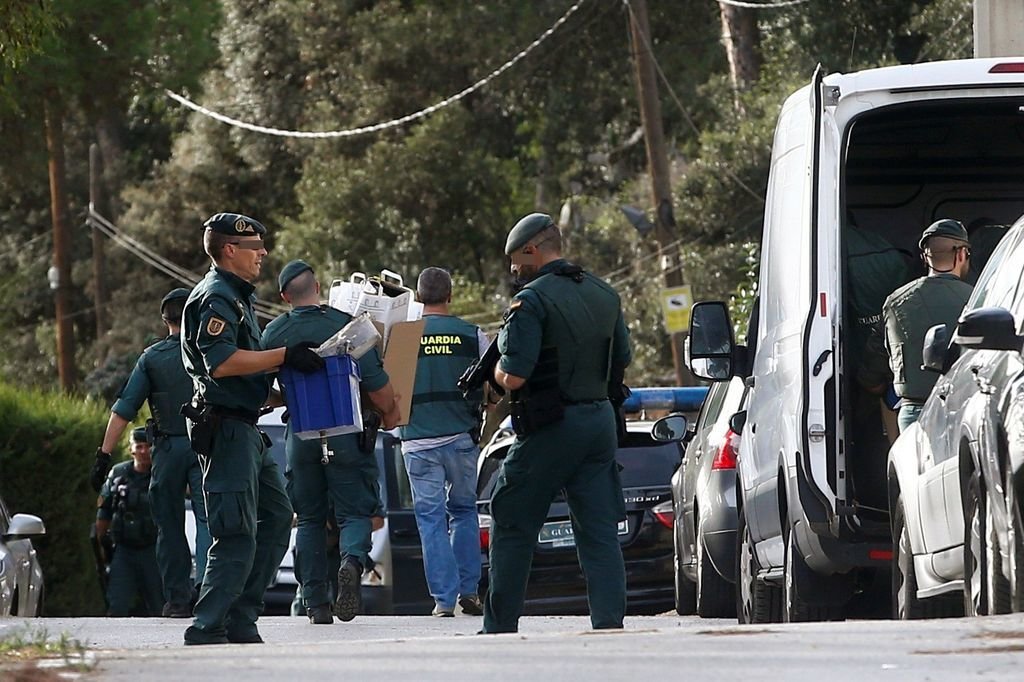 Agentes de la Guardia Civil trasladan material incautado en uno de los registros en Barcelona.